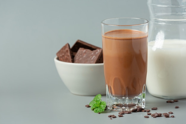 Glass of chocolate milk on the dark surface.