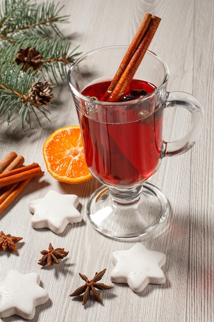 Glass of Christmas mulled wine with spices orange and cookies