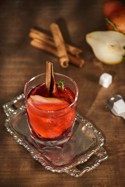 Glass of Cider pear cocktail or lemonade cinnamon sticks anise stars on wooden background