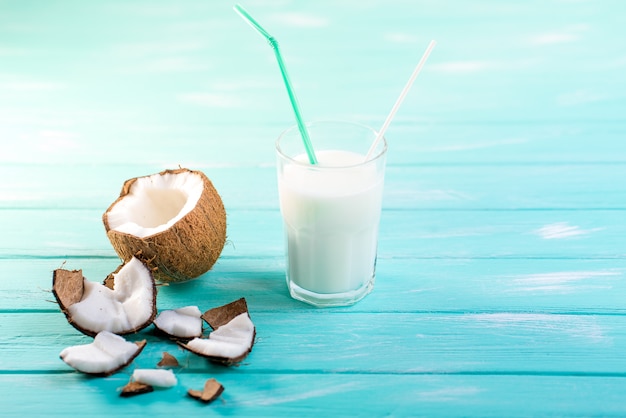 Glass of coconut milk on blue wooden table 