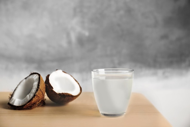 Glass of coconut milk and nuts on wooden table