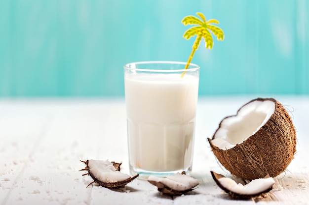 Glass of coconut milk on white wooden table. Selective focus