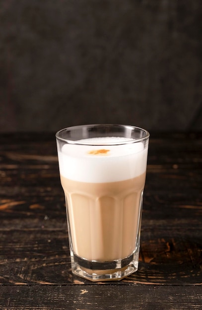 A glass of coffee on a wooden dark background. latte or cappuccino. coffee with milk