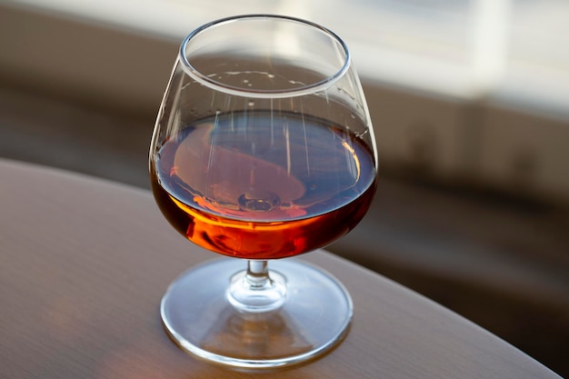 a glass of cognac on a wooden table in the bar