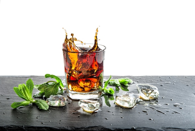 Glass of cola drink with ice and mint leaves. Cocktail aperitif juice