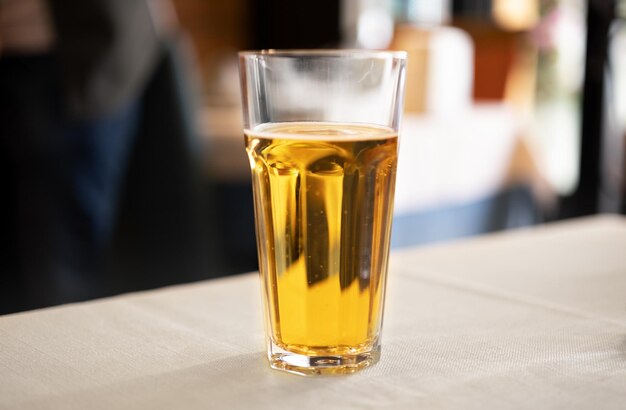 Glass of cold bitter light beer on table in cafe outdoorsCopyspace for text