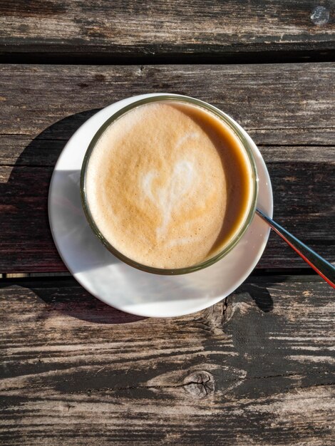 Glass cup of coffee latte on wooden table