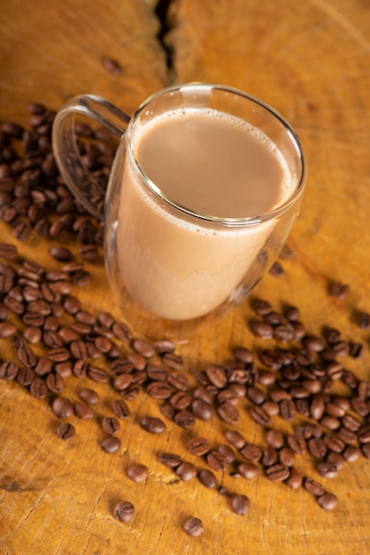 Glass cup glass cup with milk and coffee on rustic wood selective focus