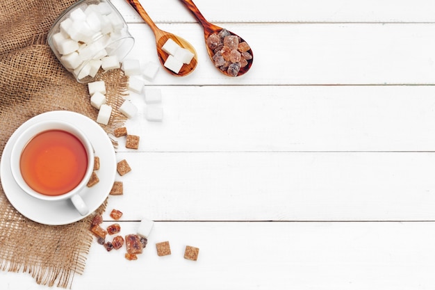 Glass cup of hot tea with sugar on the table