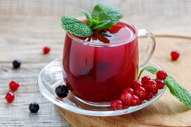 Glass cup with pudding of red and black currants and sprig of mint