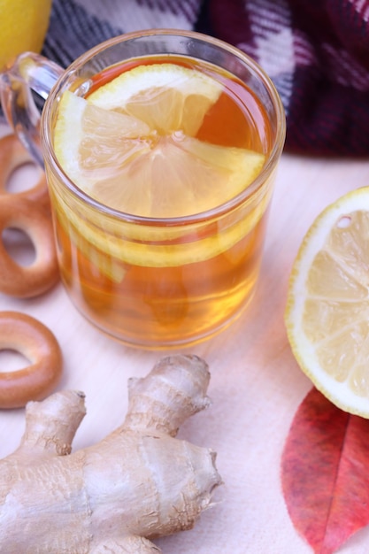 Glass cup with warm tea with lemon close-up. Autumn composition