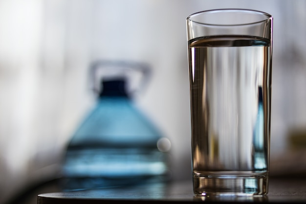 Glass Cup with water and a plastic bottle