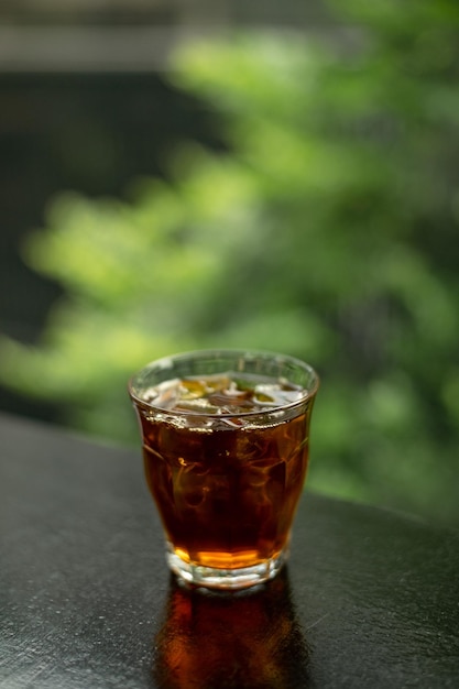 A glass of dark liquid with ice cubes in it