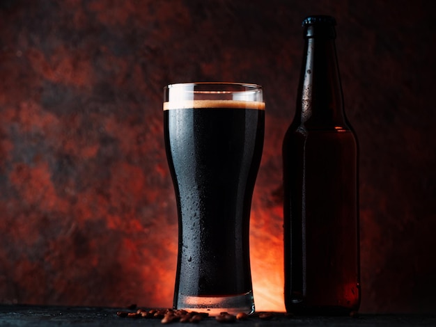 Photo a glass of dark porter beer with coffee added a glass on a rusty brown background with a backlight