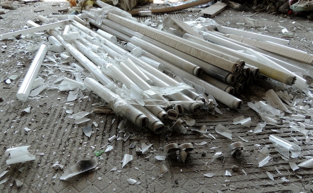 Glass Debris Of Crushed Tube Lamps On Dirty Cement Floor
