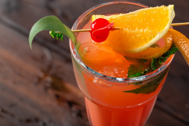 Glass of delicious alcoholic cocktail on dark background