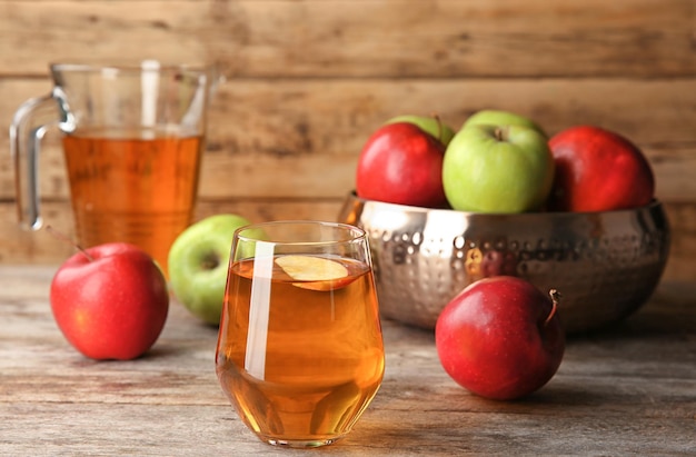 Glass of delicious apple juice on table