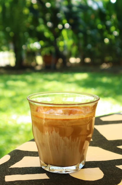 Glass of Dirty Latte Coffee Served on Garden Table