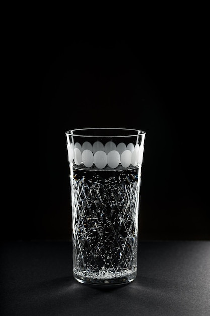 Glass of drink water with gas on black background