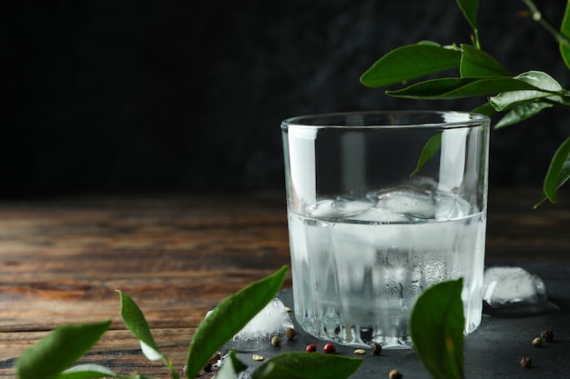 Glass of drink with ice on wooden table