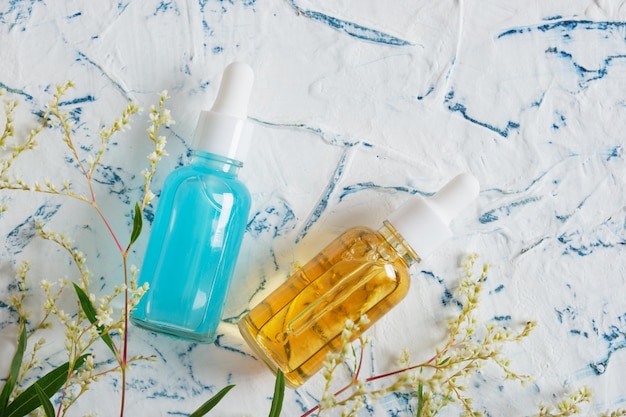 Glass dropper bottles and beautiful yellow flowers natural cosmetic concept