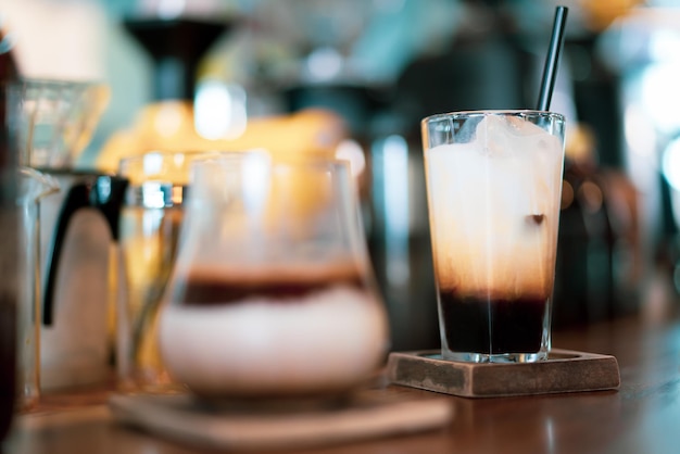 Glass of espresso shot with milk on bar at cafe, beatiful light bokeh as background