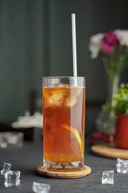 Glass of espresso with lemon juice and fresh sliced lemon on wooden table