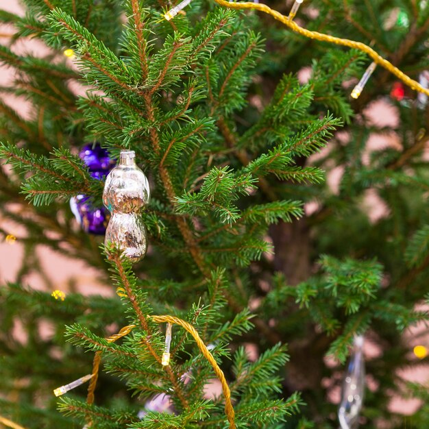 Glass figure and garland lights on christmas tree