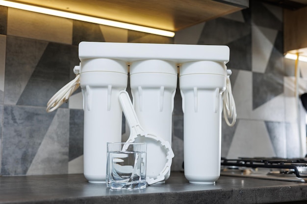 A glass of filtered water Water filtration system with replaceable cartridges A system in the apartment with three tanks for cleaning tap water