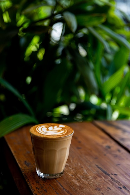 Glass of flat white coffee with heart shaped foam milk