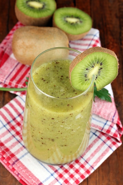 Photo glass of fresh kiwi juice on wooden table