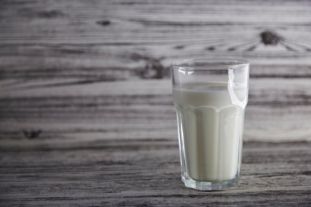 Glass of fresh milk on the wooden vintage background with copy space Organic milk Healthy wellness background