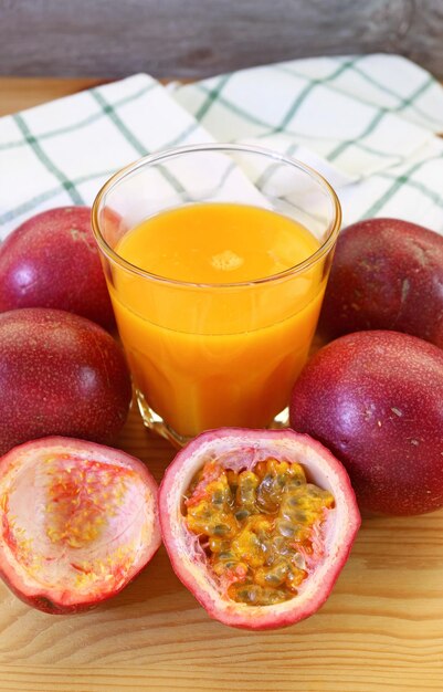 Glass of Fresh Passion Fruit Juice with Heap of Cut and Whole Fruits