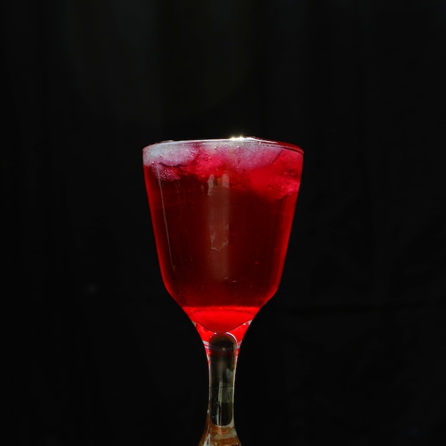 Glass of fresh red ice isolated on black background