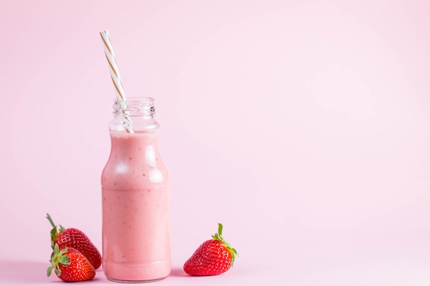 Glass of fresh strawberry milkshake, smoothie and fresh strawberries