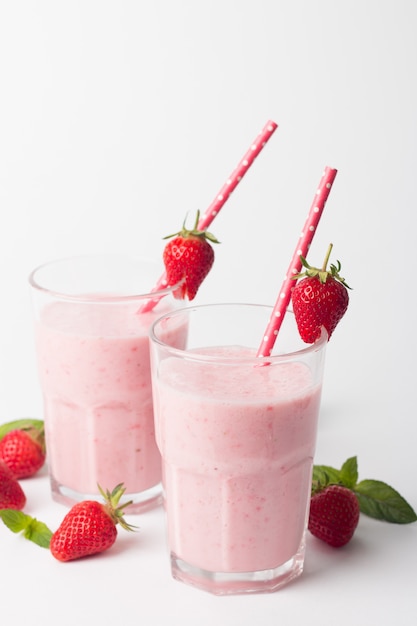 Glass of fresh strawberry smoothie on a white background