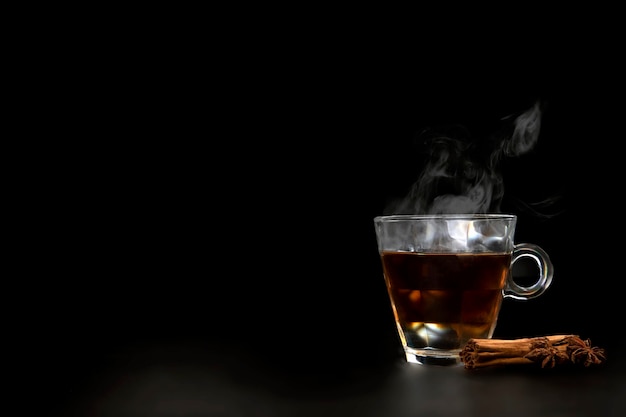 A glass of freshly brewed black teaescaping steamwarm soft light darker background copy space