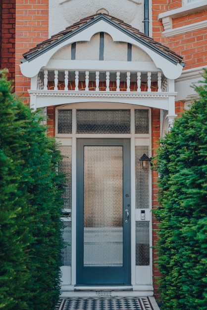 Photo glass front door of a traditional edwardian house in london uk greenery leading to it