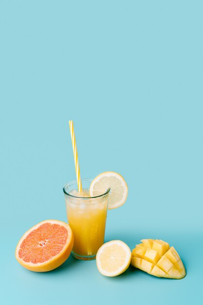 Glass of fruit juice with straw to a fresh exotic fruit