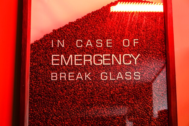 Glass full of coffee beans and the text in case of emergency break glass