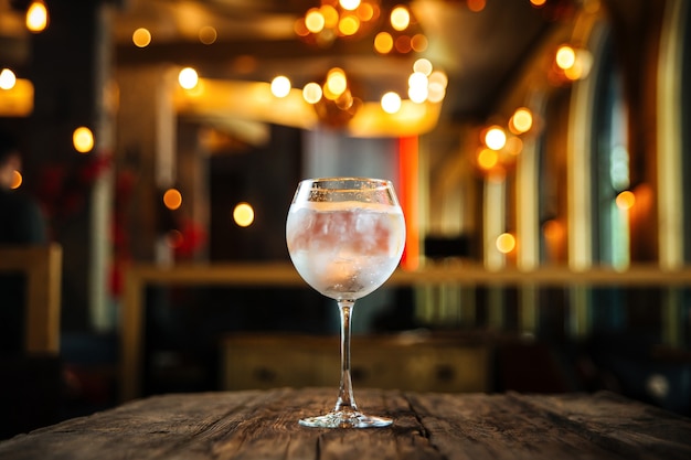 Glass of gin tonic cocktail on the wooden desk