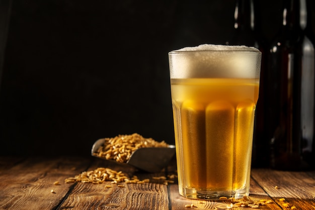 Glass of homemade beer on a wooden table. Glass of craft beer on a dark background.