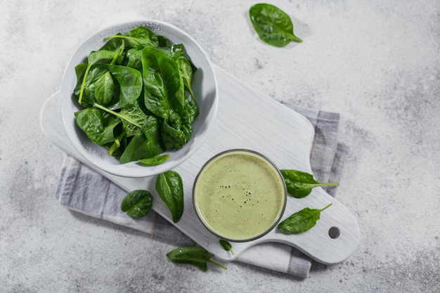 Glass of homemade healthy green smoothie with fresh baby spinach