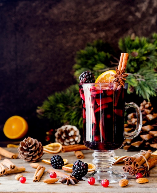 Glass of hot mulled wine with ingredients