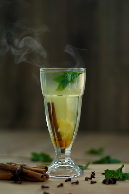 Glass of hot vitamin tea on wooden table. winter hot seasonal drinks