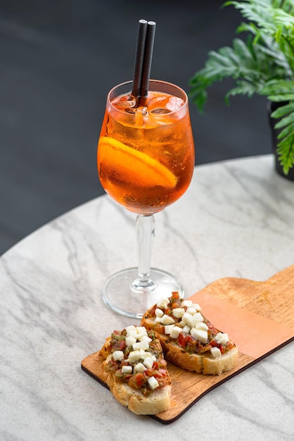 Glass of ice cocktail Aperol spritz and bruschetta