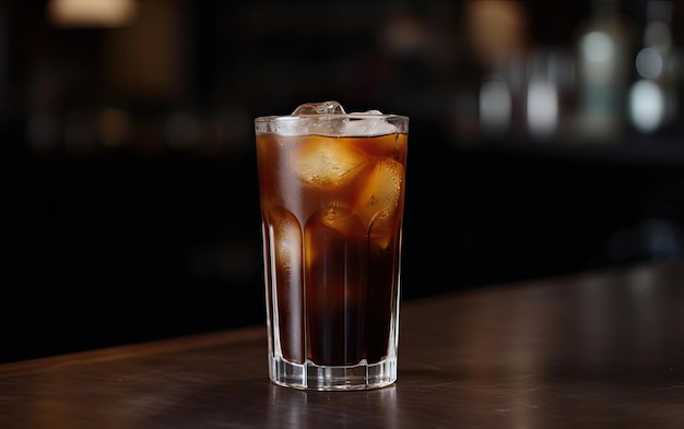 A glass of iced coffee sits on a bar counter.