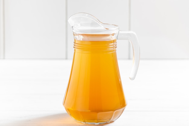 Glass jar of apple fruit drink on wooden table