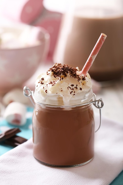 Glass jar of chocolate milk on table closeup