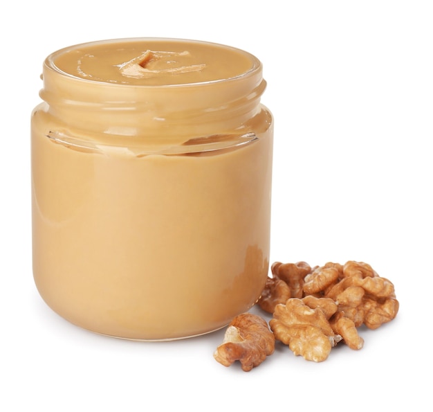 Glass jar of creamy walnut butter and nuts on white background